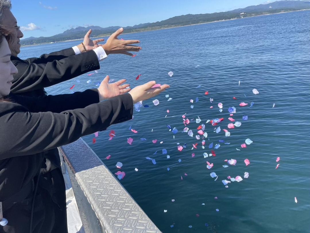 海に向かって静かに手を合わせる合掌